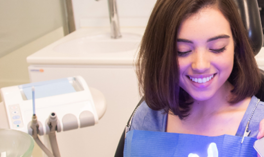 Mujer en una clínica de Smysecret mientras recibe asesoramiento sobre su tratamiento de blanqueamiento dental.