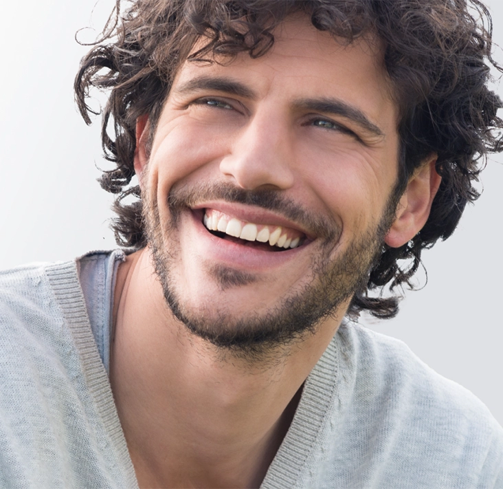 Hombre sonriente tras haber recibido un tratamiento de carillas dentales mínimamente invasivas en Smysecret.