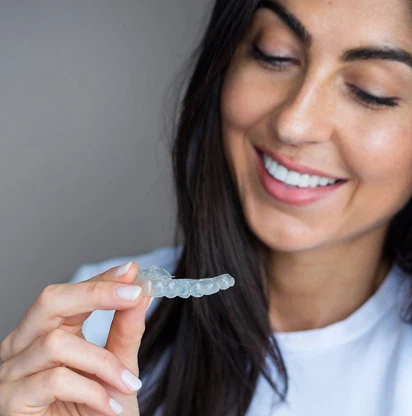 Chica sonriente posa con un aparato de ortodoncia invisible de Smysecret.